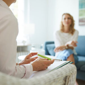 Individual Counselling Session with a therapist taking notes and a client sitting on a couch