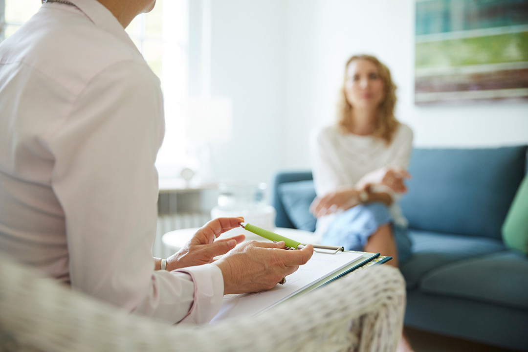 Individual Counselling Session with a therapist taking notes and a client sitting on a couch